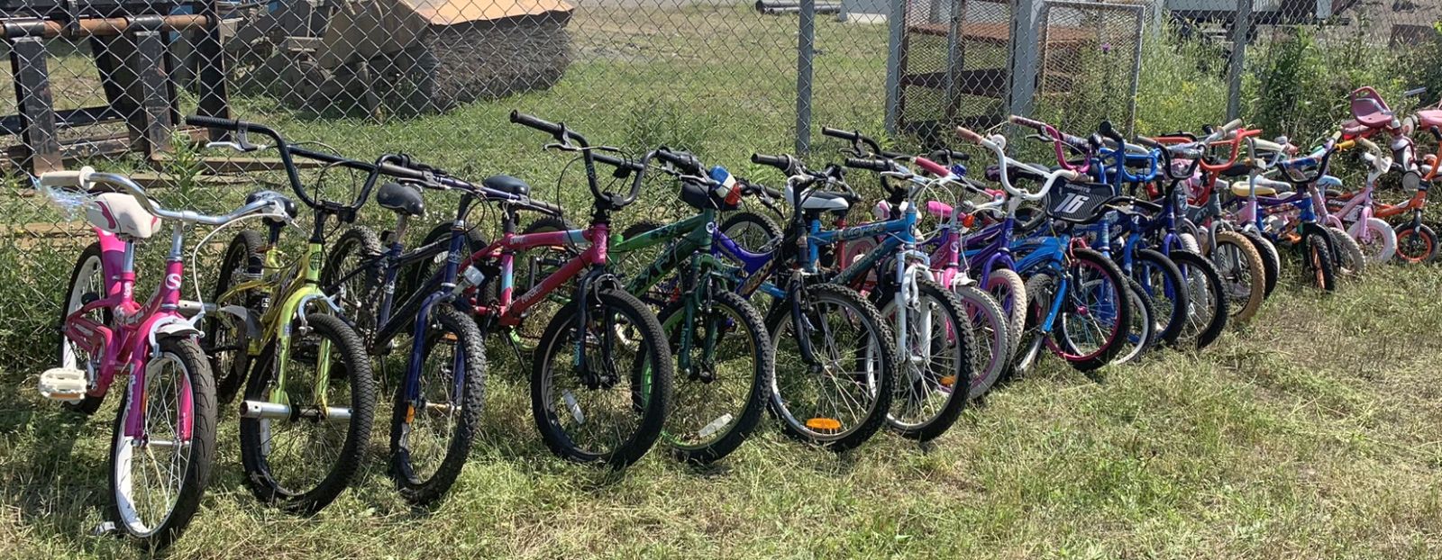 used children's bicycles against chain-link fence