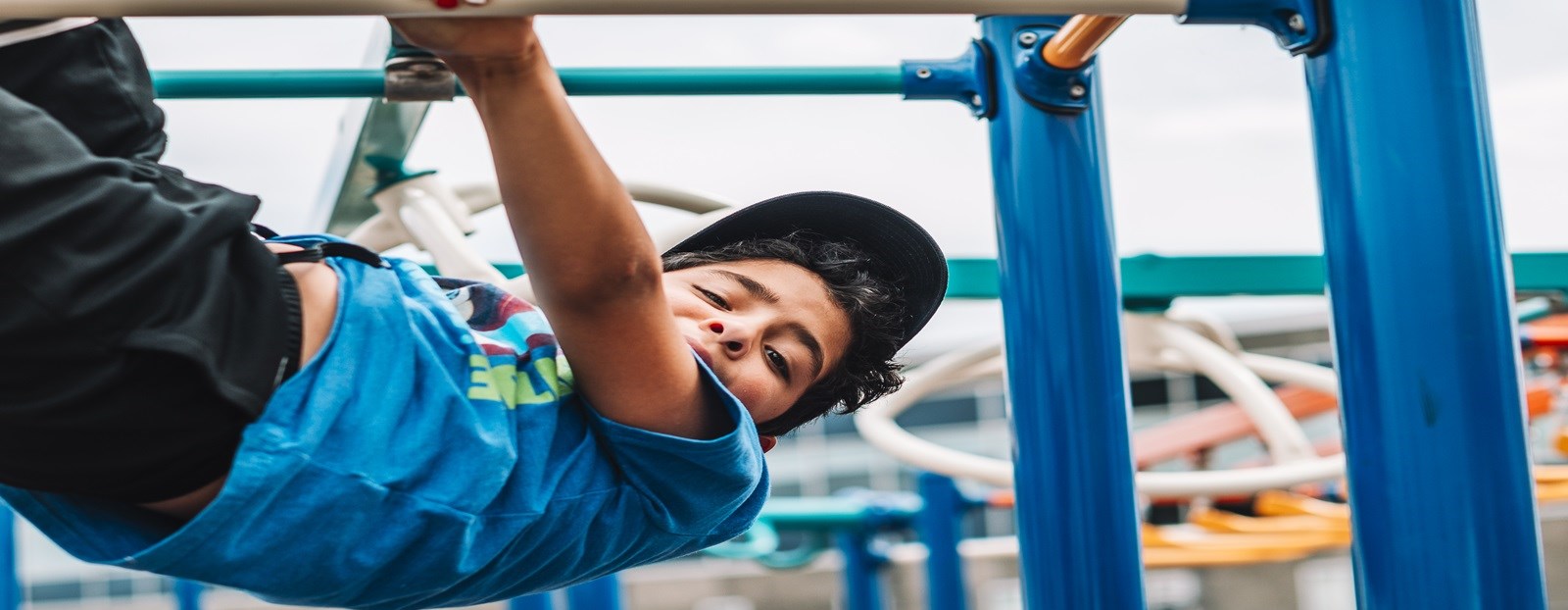 Kid hanging on the monkeybars