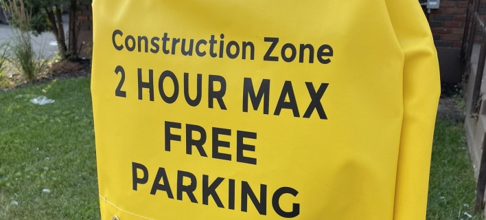 A parking meter cover noting two hour parking in a construction area